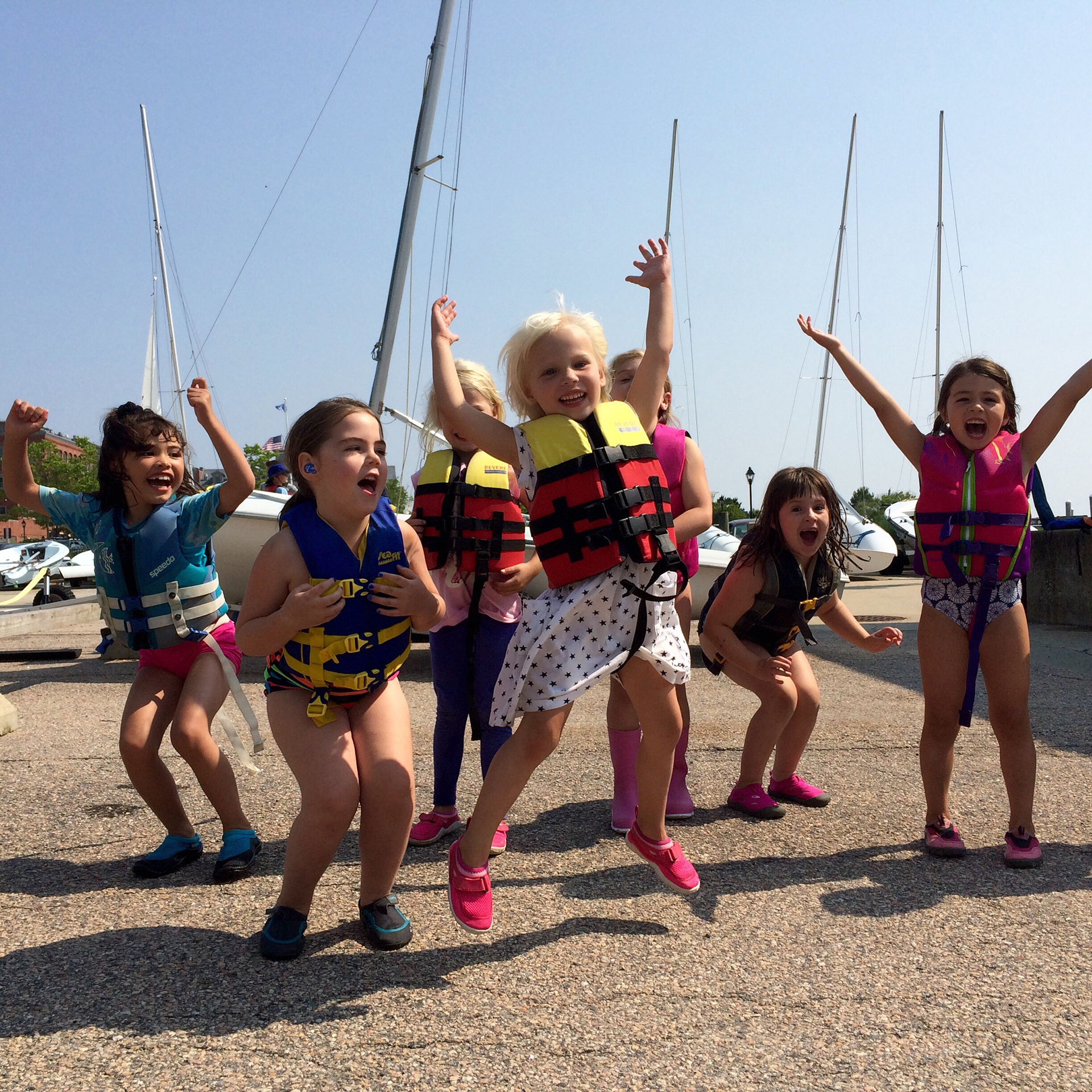 Children in life jackets playing on a beach