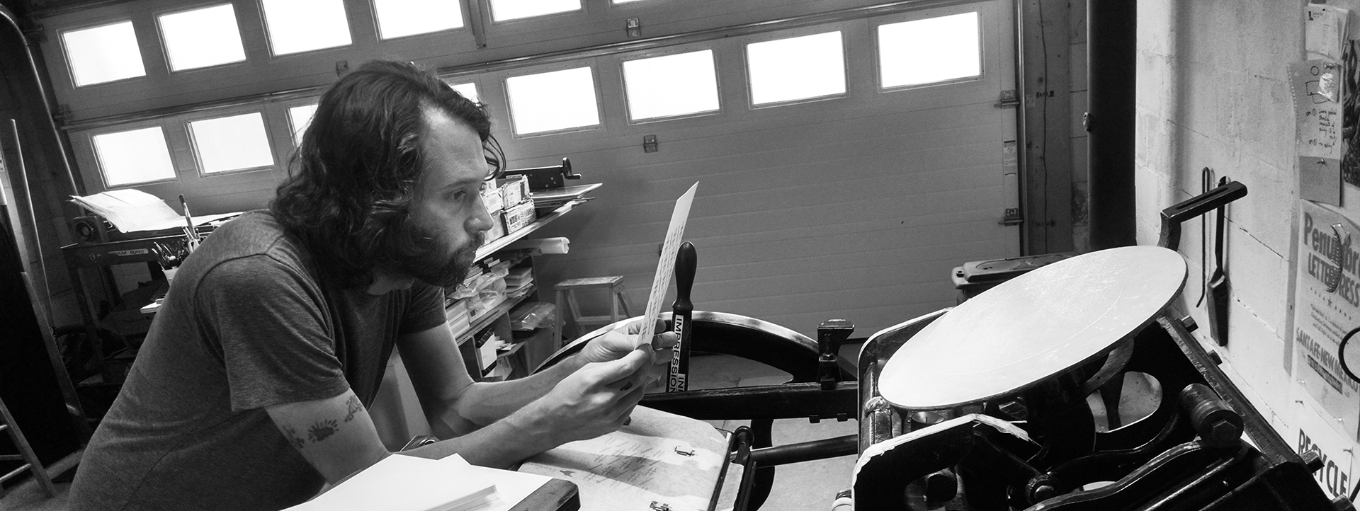 black and white photograph of Chris Fritton working at a letterpress machine