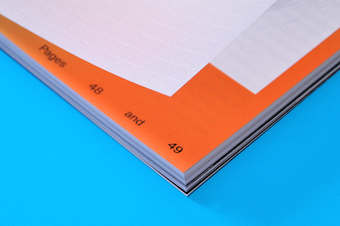 close-up of the corner of a booklet with bright orange printing
