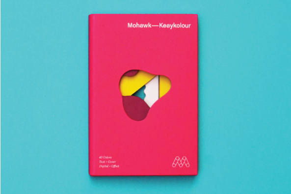 Bright pink Keaykolour packaging on teal paper