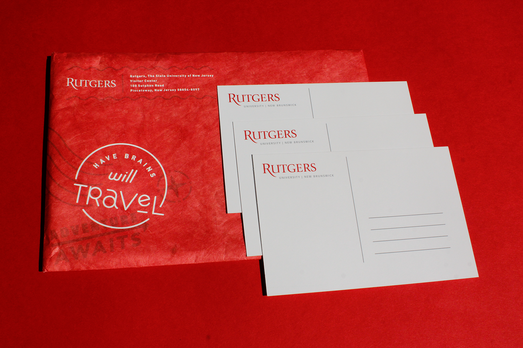 Postcards and a mailer on a red backdrop