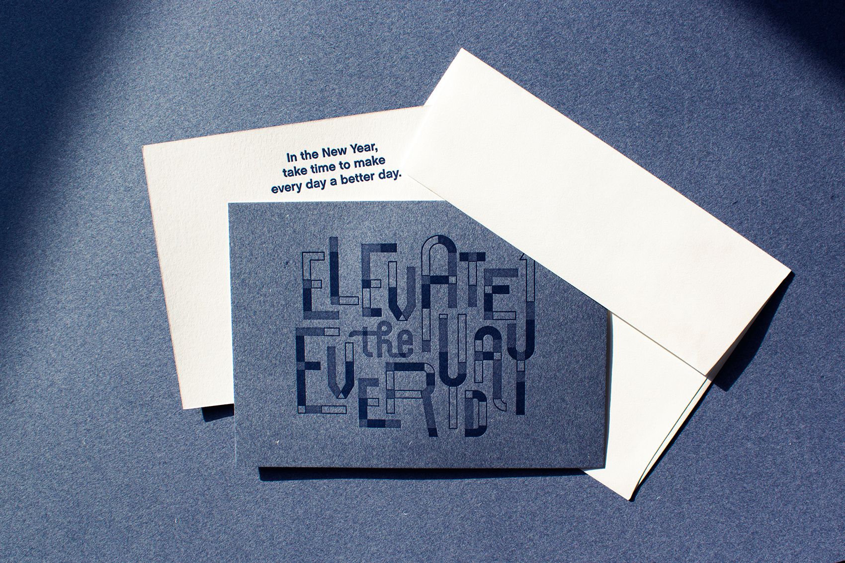Elevate the Everyday card photographed on a matching background, accompanied by its envelope