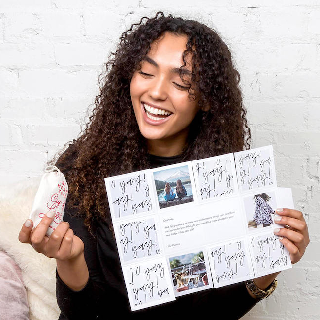 A woman holding an unfolded Greetabl gift