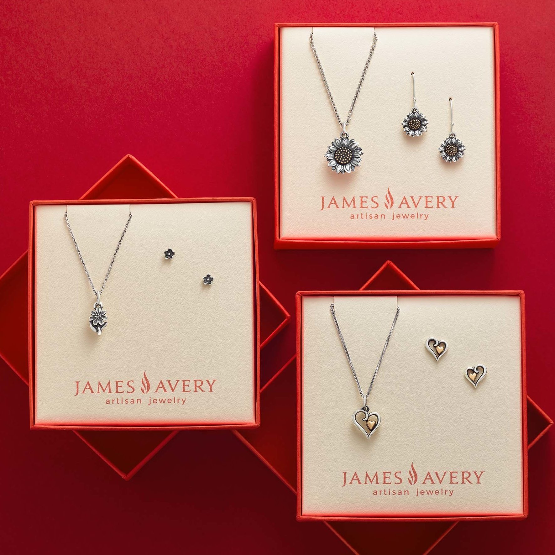 three boxes of James Avery jewelry on a red background