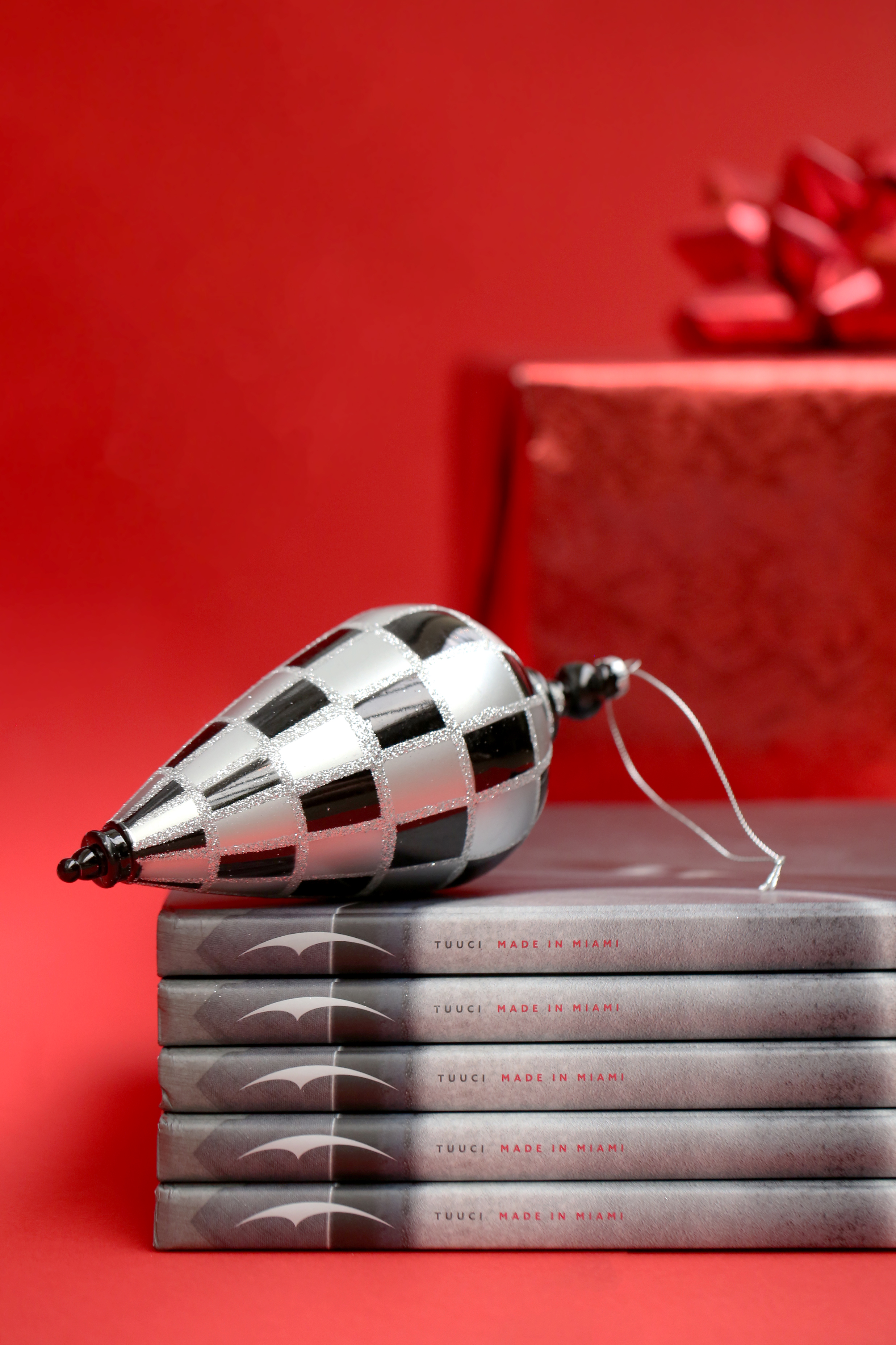 Spines of several Taste of Tucci books with a holiday ornament on top