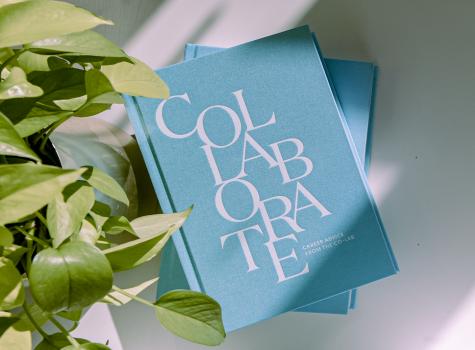 two co-lab books on a table beside a plant